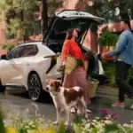 Couple and their dog loading up the trunk of a 2027 Toyota bZ