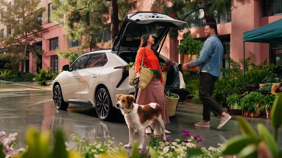 Couple and their dog loading up the trunk of a 2027 Toyota bZ