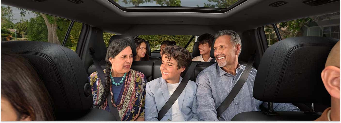 Black leather three-row interior seating of a 2026 Chevrolet Traverse with passengers.