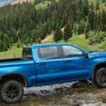 blue silverado 1500 crossing a stream