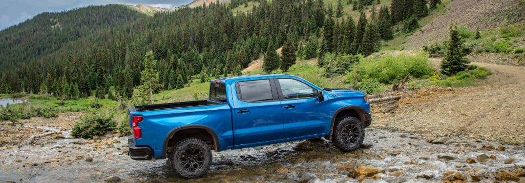 blue silverado 1500 crossing a stream