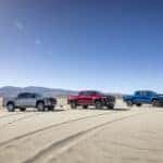 From right to left: pack shot of Colorado Z71, Trail Boss and ZR2 in sandy dessert.