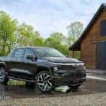 Black 2024 Chevrolet Silverado EV RST on driveway beside a barn