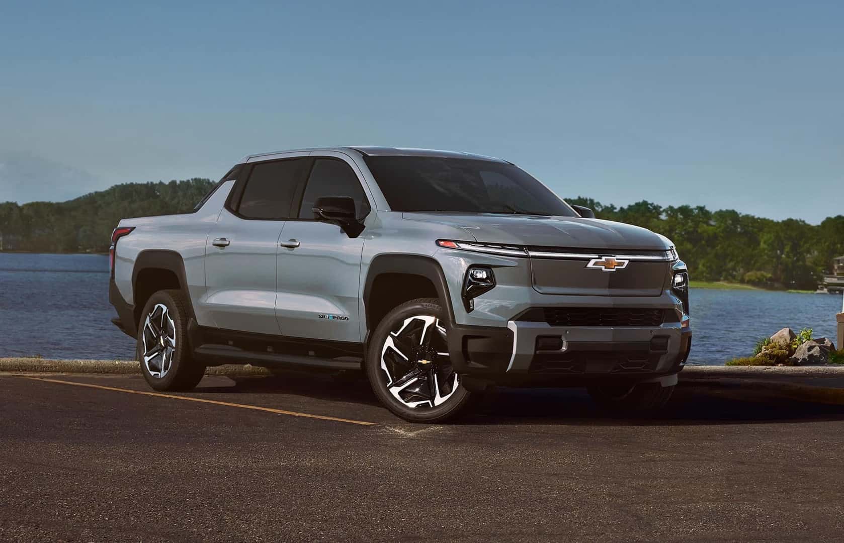 A Sexy 2025 Chevrolet Silverado EV Parked In A Parking Lot Near A Lake