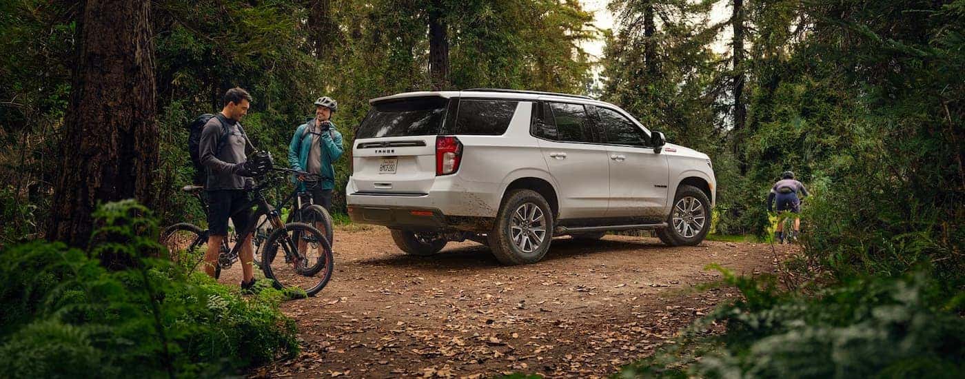 A white 2022 Chevy Tahoe Z71 is shown near a biking path in the woods.