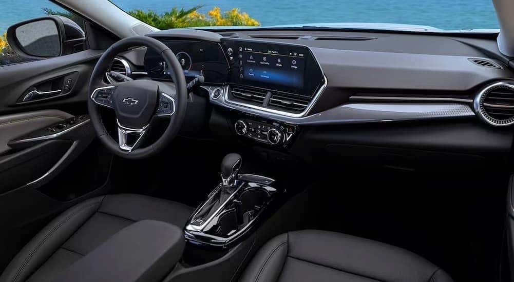 The black and gray interior and dash of a 2024 Chevy Trax is shown.