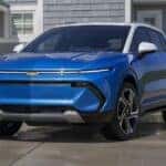 A blue 2024 Chevy Equinox EV is shown from the front at an angle after leaving a dealer that has a dealer that has a Chevy Equinox for sale.