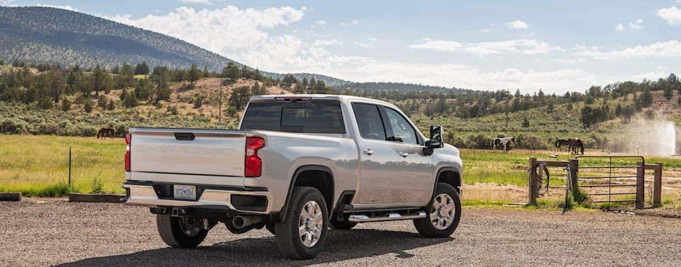 A silver 2022 Chevy Silverado 2500 HD is shown from the rear at an angle after leaving a dealer that has a Chevy Silverado 2500 for sale.