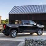 A black 2024 Chevy Silverado 2500 HD High Country is shown from the side.