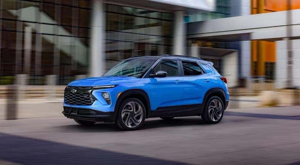 A blue 2024 Chevy Trailblazer RS is shown driving in a city.