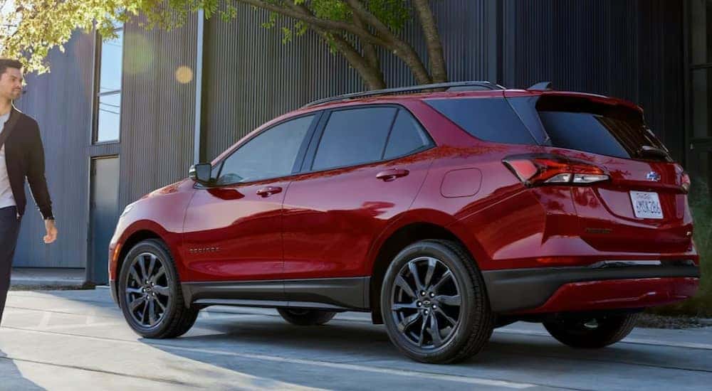 A red 2024 Chevy Equinox RS is shown parked near a person walking.