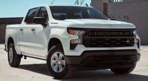 A white 2024 Chevy Silverado 1500 WT is shown parked near a building after viewing trucks for sale in Shreveport..