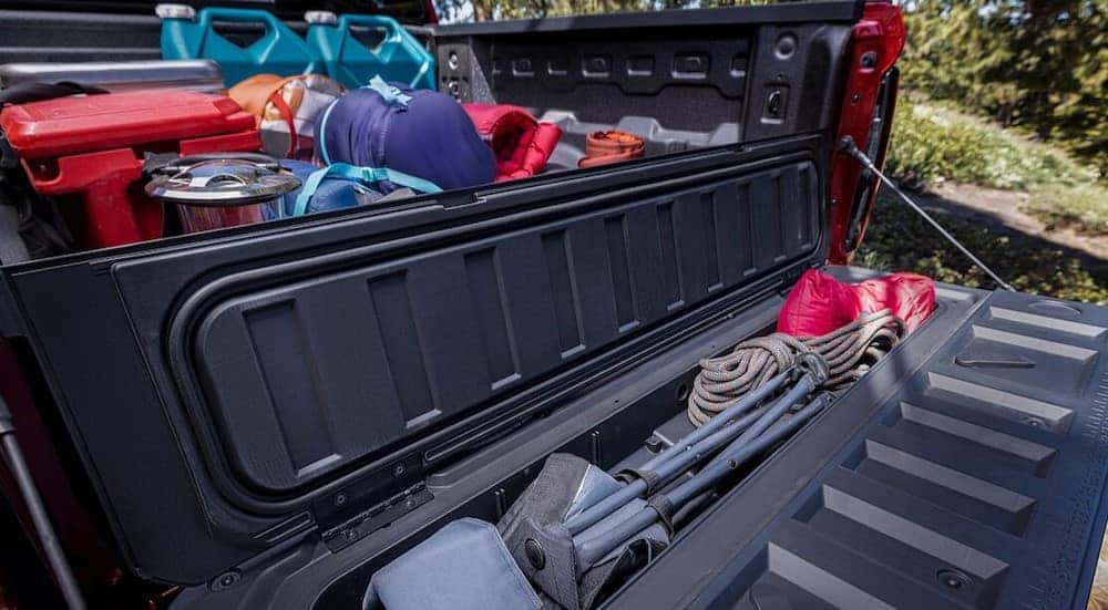 A close-up of the segment-first StowFlex tailgate is shown on a red 2024 Chevy Colorado Trail Boss.