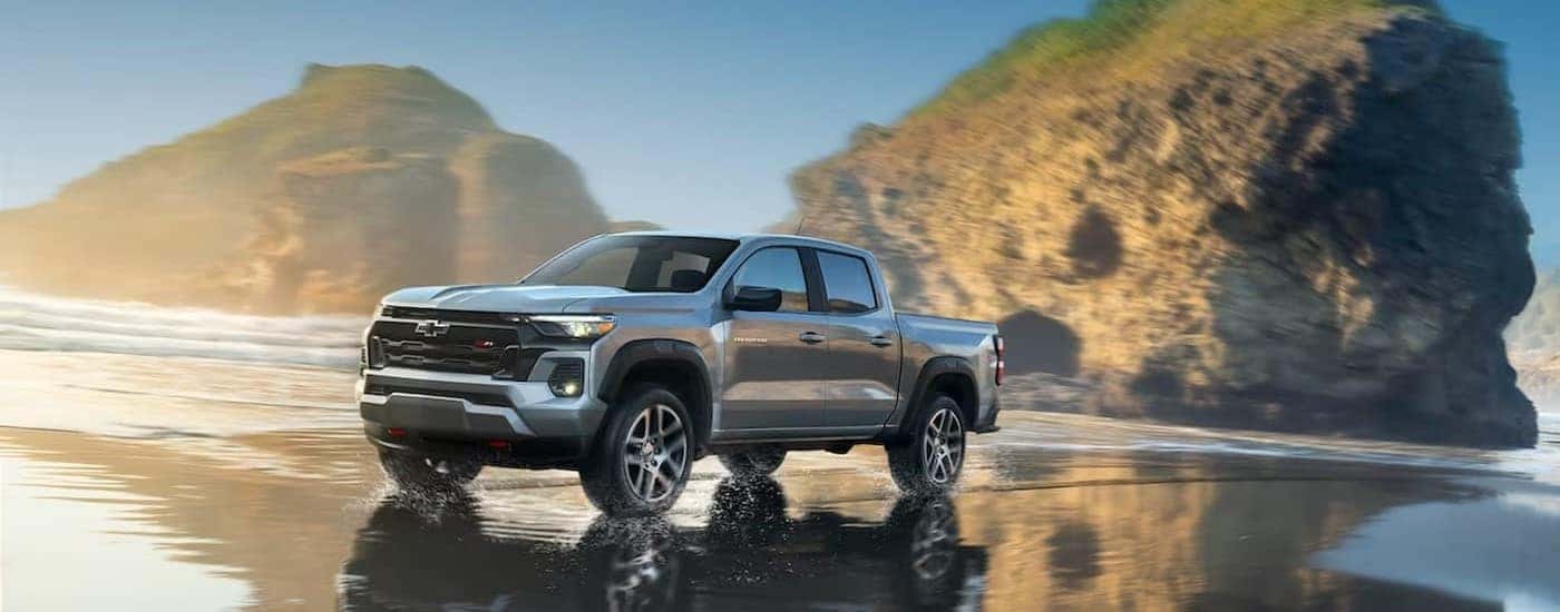 A silver 2024 Chevy Colorado Z71 is shown driving on a beach.