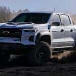 A white 2024 Chevy Colorado ZR2 Bison is shown driving off-road after viewing trucks for sale in Shreveport.