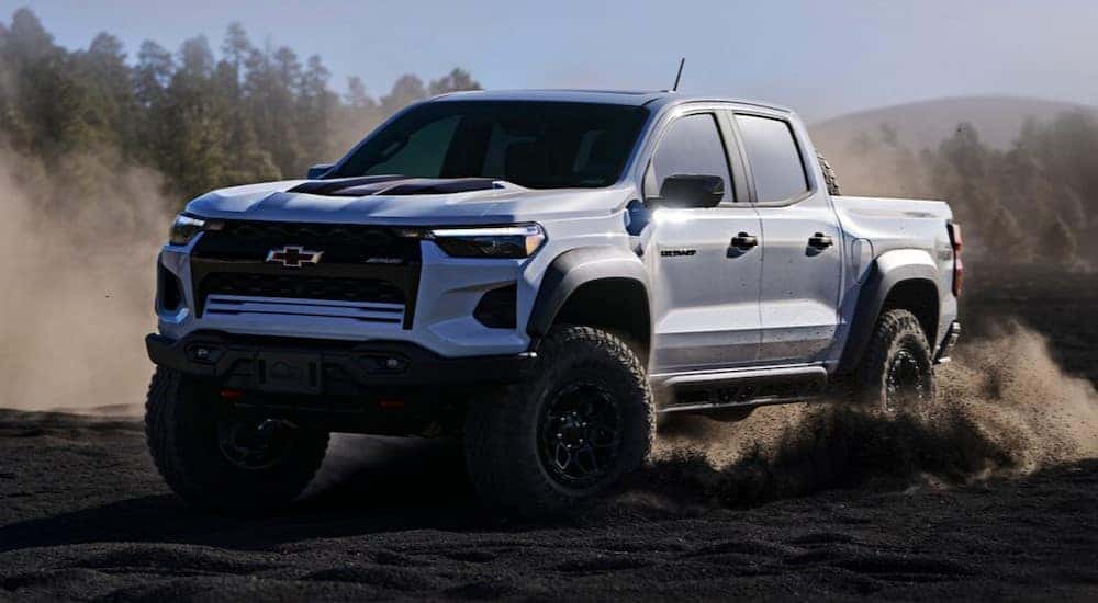A white 2024 Chevy Colorado ZR2 Bison is shown driving off-road after viewing trucks for sale in Shreveport.