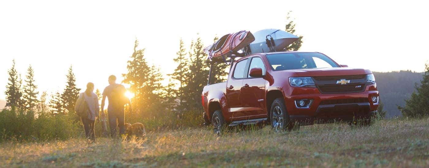 People are shown hiking near a red 2015 Chevy Colorado Z71.