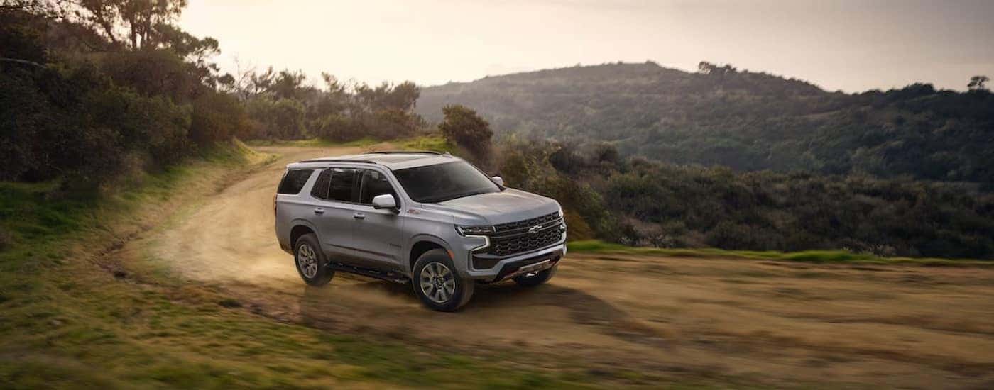 A silver 2024 Chevy Tahoe Z71 is shown off-roading.