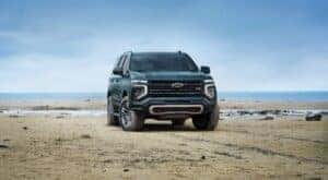 A green 2025 Chevy Tahoe Z71 is shown parked off-road.