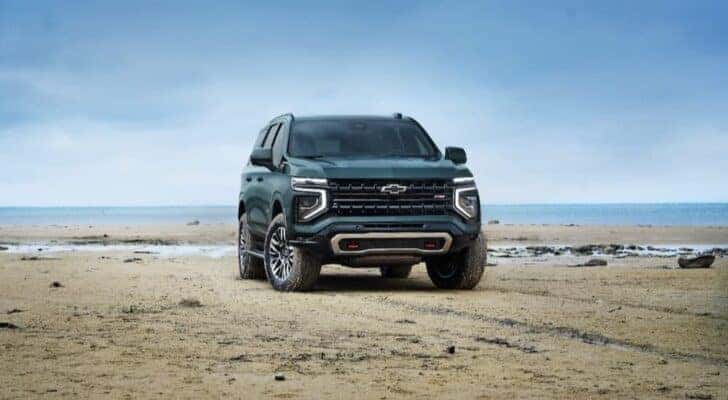 A green 2025 Chevy Tahoe Z71 is shown parked off-road.
