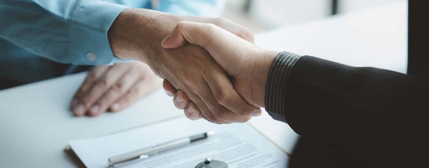 Two people are shown shaking hands.