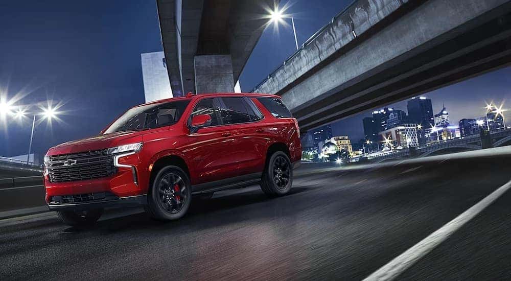 A red 2024 Chevy Tahoe RST driving under a bridge.