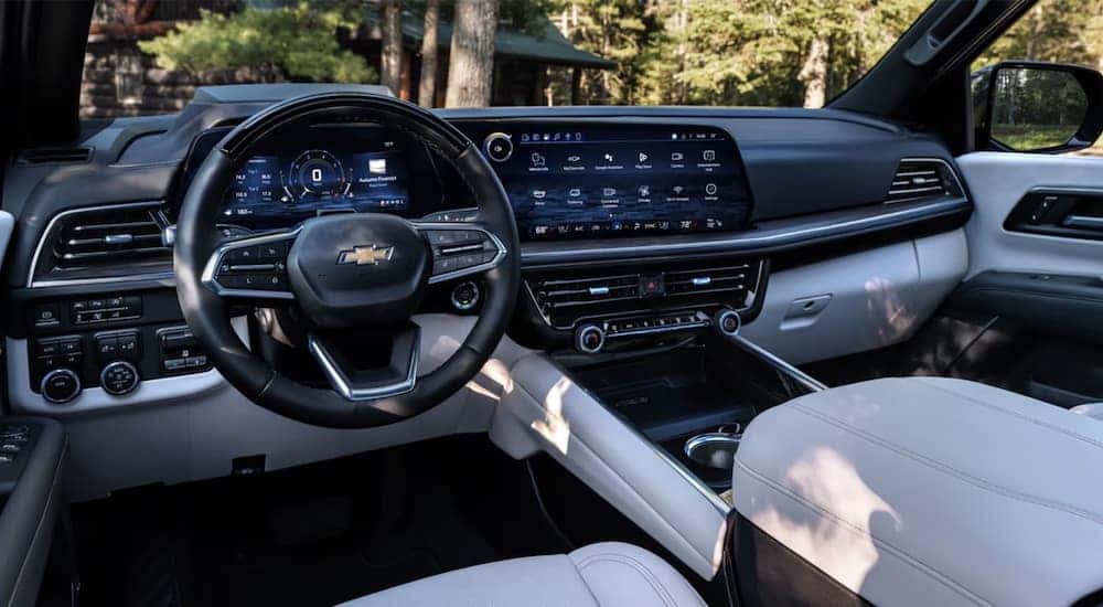 The black and white steering wheel and dashboard in the interior of a 2025 Chevy Tahoe.