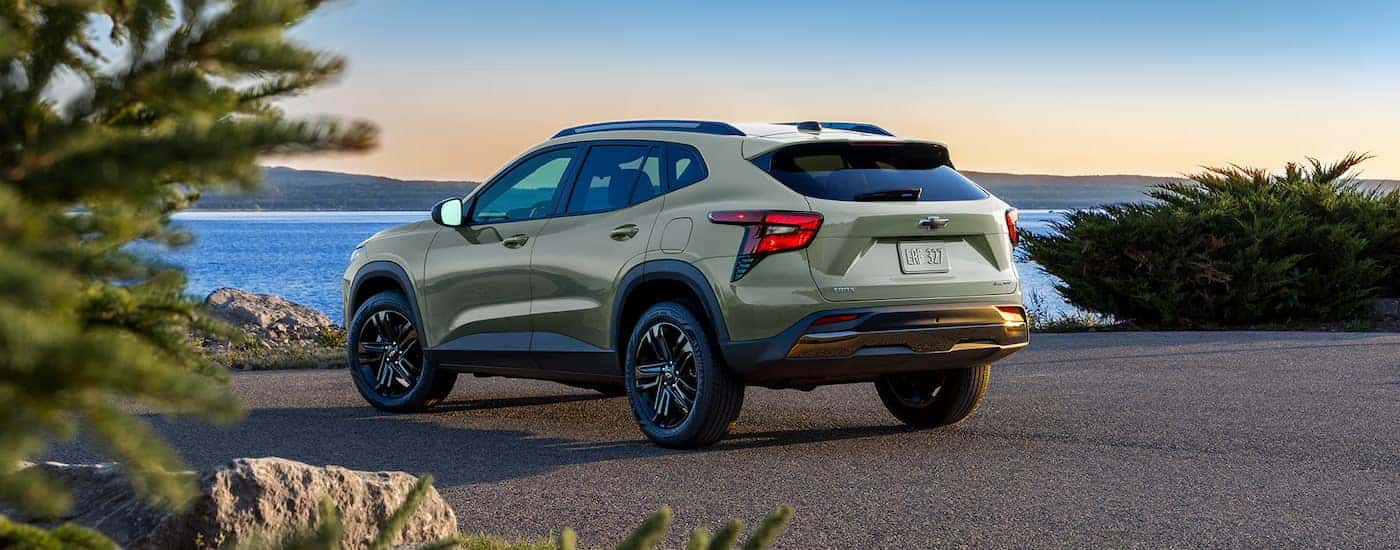 Rear view of a light green 2025 Chevy Trax ACTIV parked near water.