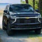 A blue 2025 Chevy Tahoe Premier driving to a Chevy dealer near Bossier City.