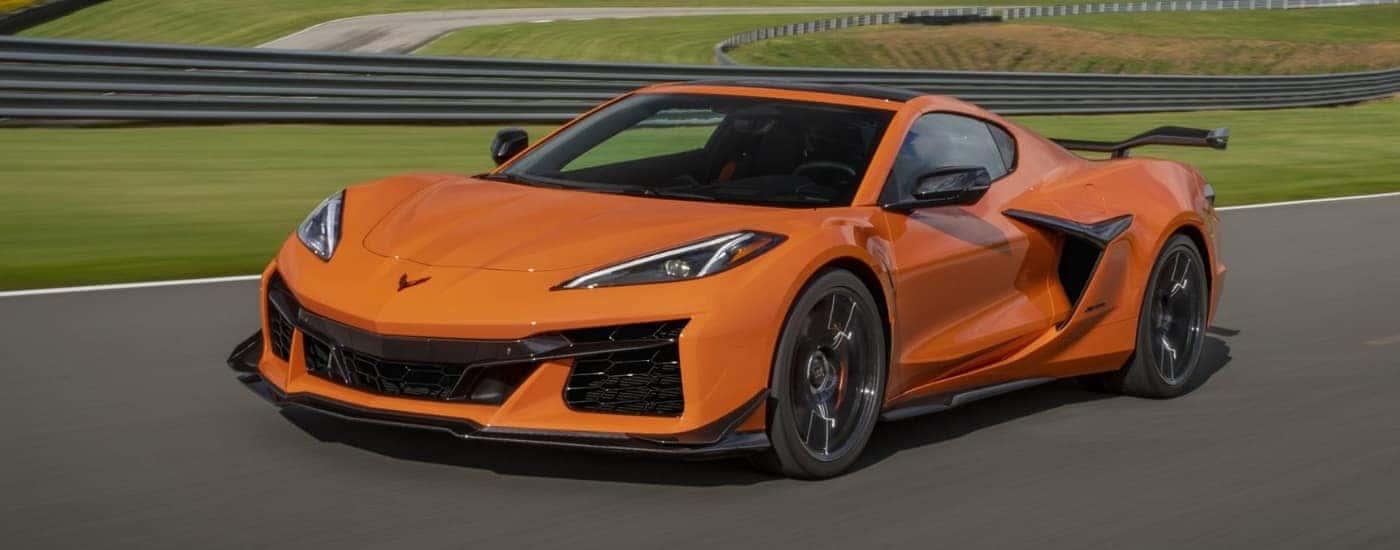 An orange 2024 Chevy Corvette Z06 is shown from the front at an angle.