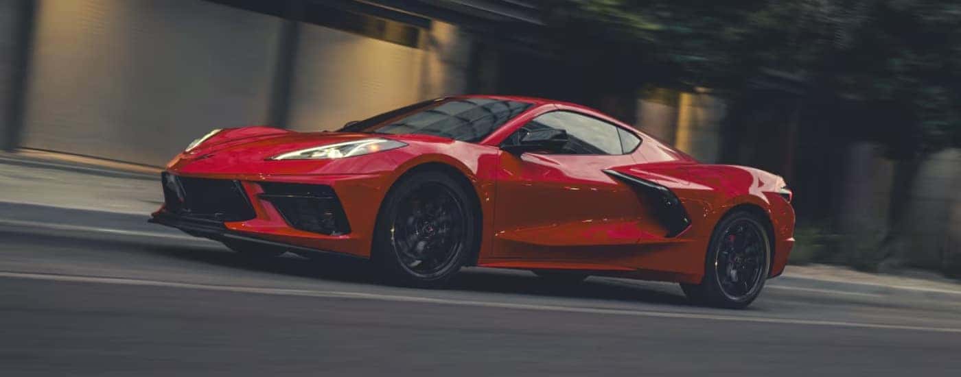 A red 2025 Chevy Corvette Stingray is shown driving to a Chevy dealer near Marshall.