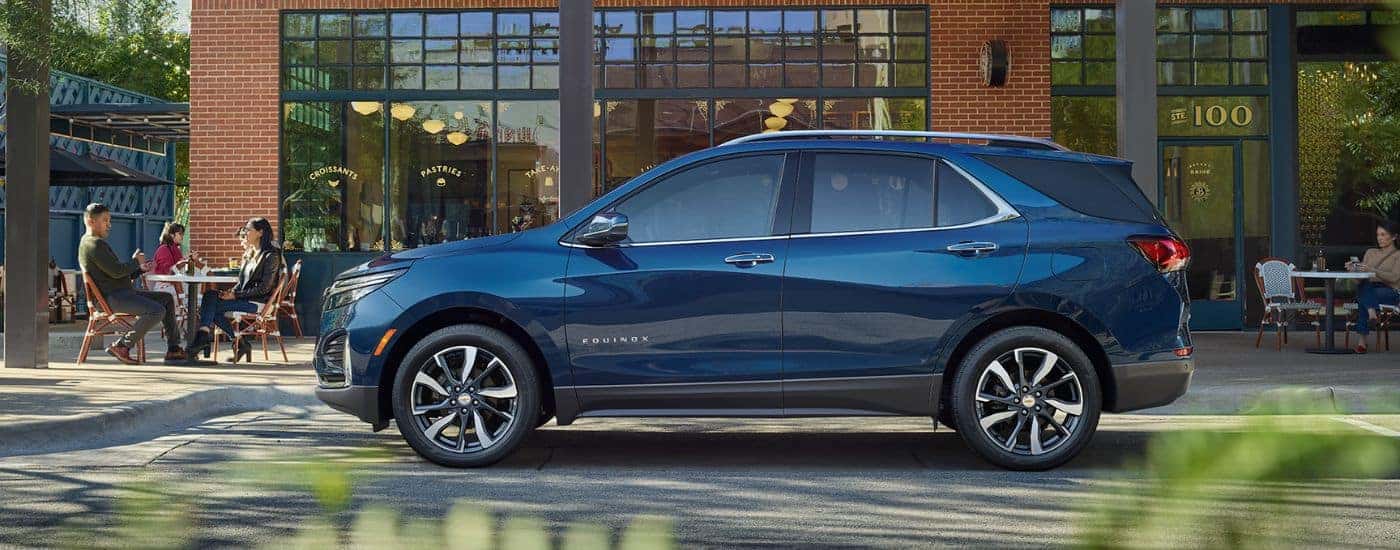A blue 2022 Chevy Equinox in front of a brick building.