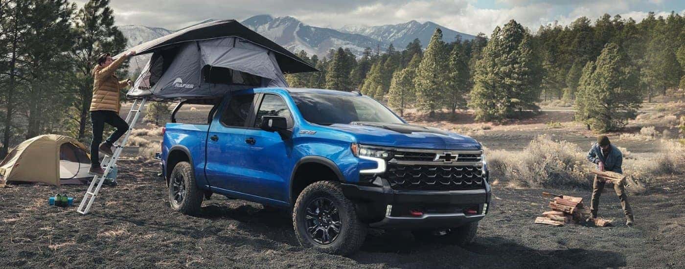 People setting up a campsite near a blue 2023 Chevy Silverado 1500 ZR2.