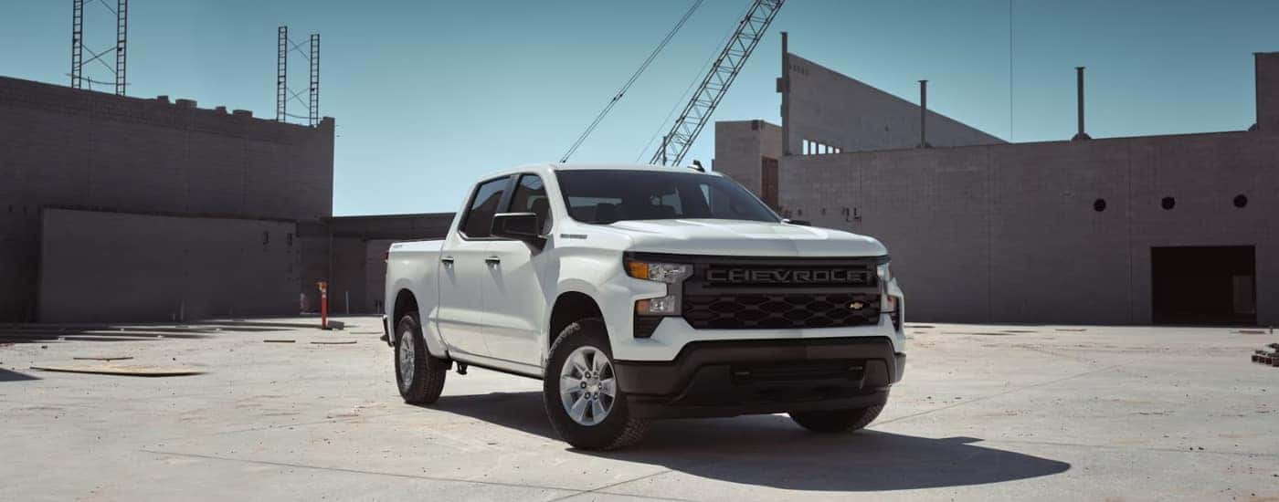 A white 2024 Chevy Silverado 1500 WT is shown parked near a building after viewing trucks for sale in Shreveport..