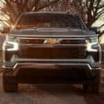 A silver 2025 Chevy Silverado 1500 driving on a dirt road