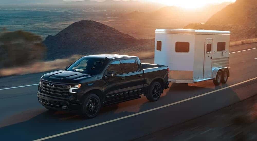 A black 2025 Chevy Silverado 1500 High Country for sale near Ruston is towing a trailer.