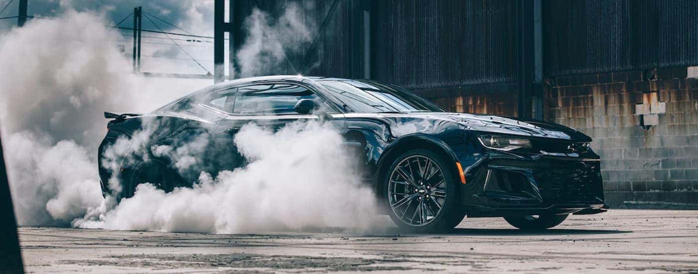 Black 2022 Chevy Camaro performing a burnout.
