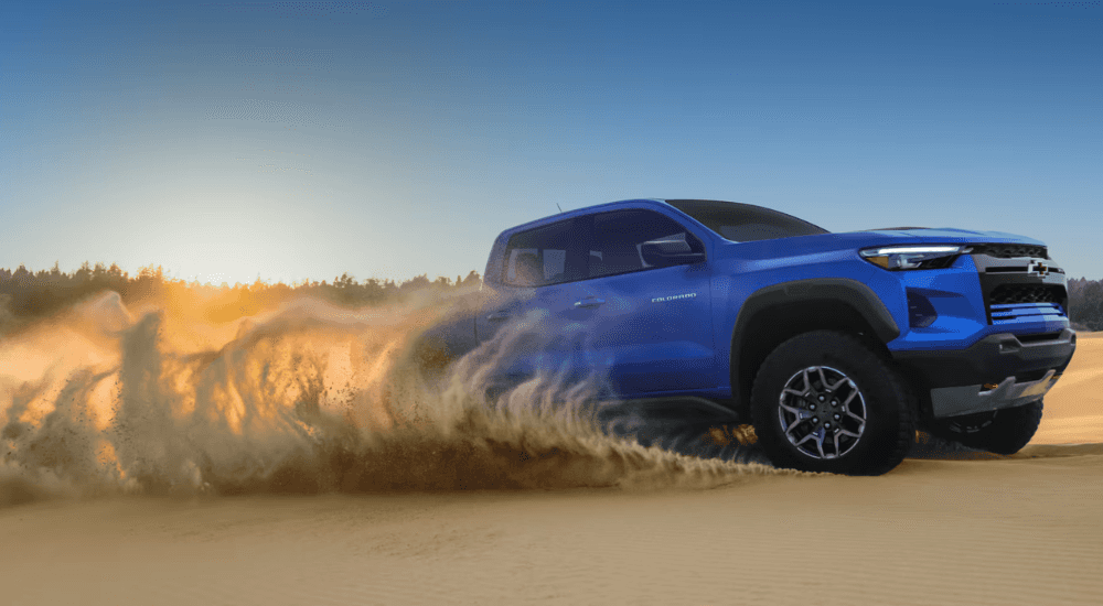 Blue 2026 Chevy Colorado driving on a sand dune