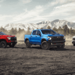 A red, a blue, and a white 2026 Chevy Silverado 1500 parked side by side