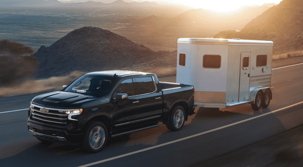 Black 2026 Chevy Silverado 1500 High Country LD towing a trailer