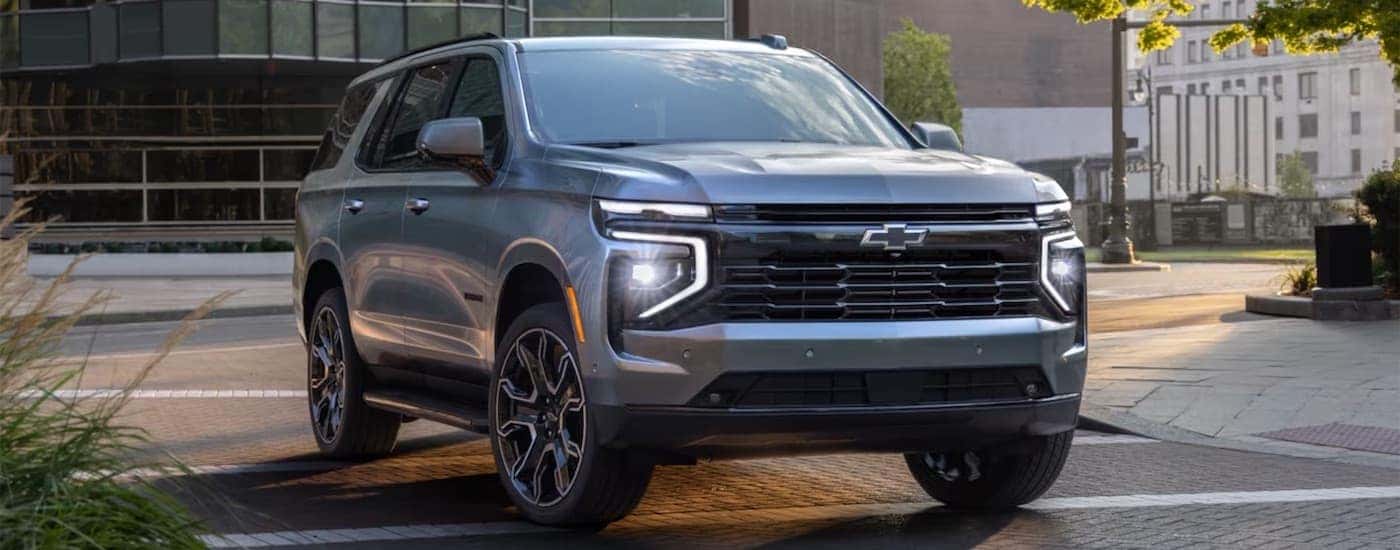 Silver 2025 Chevy Tahoe driving on a road.