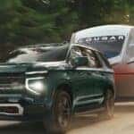 A green 2026 Chevy Tahoe Z71 towing a trailer.