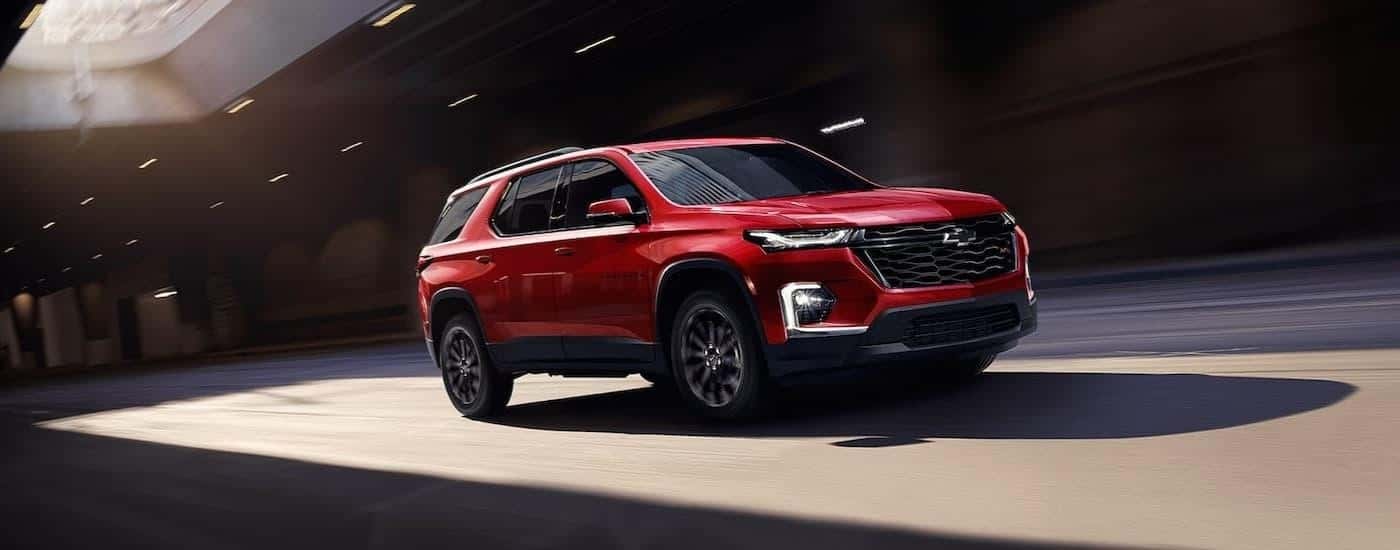 A red 2022 Chevy Traverse RS driving in a city