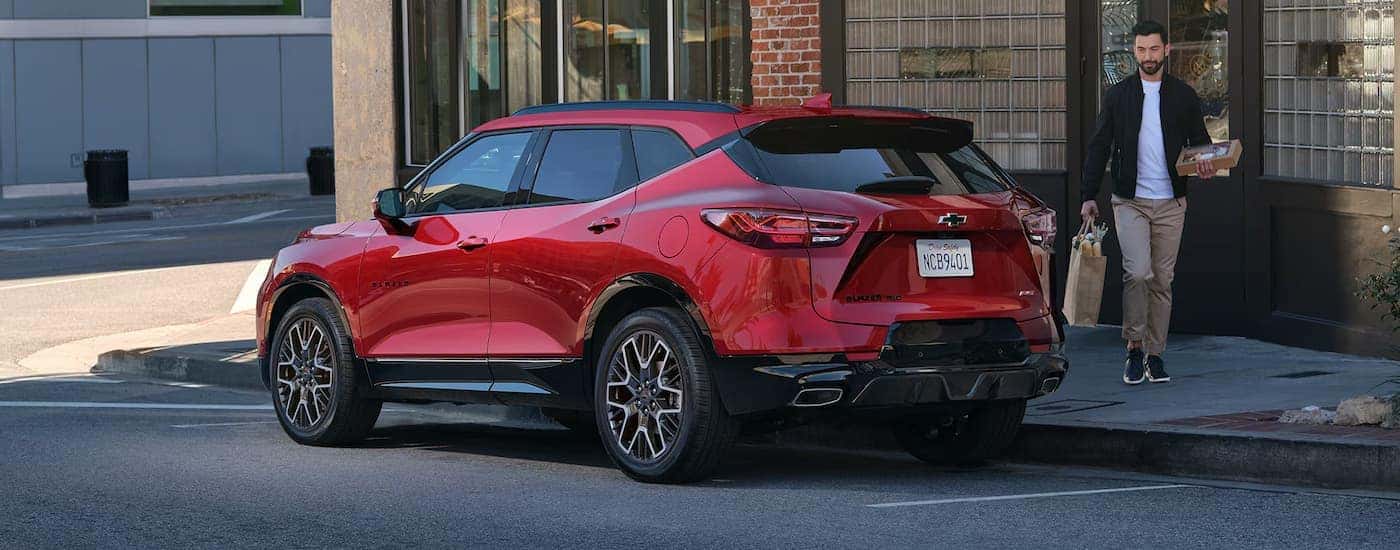 Rear of a red 2026 Chevy Blazer EV parked by a curb.