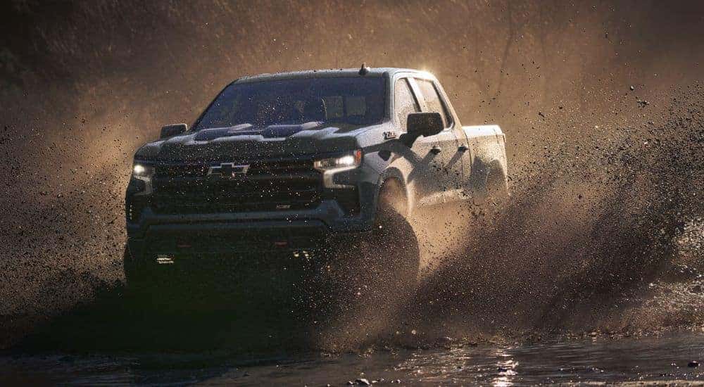 Blue 2026 Chevy Silverado 1500 driving through the mud