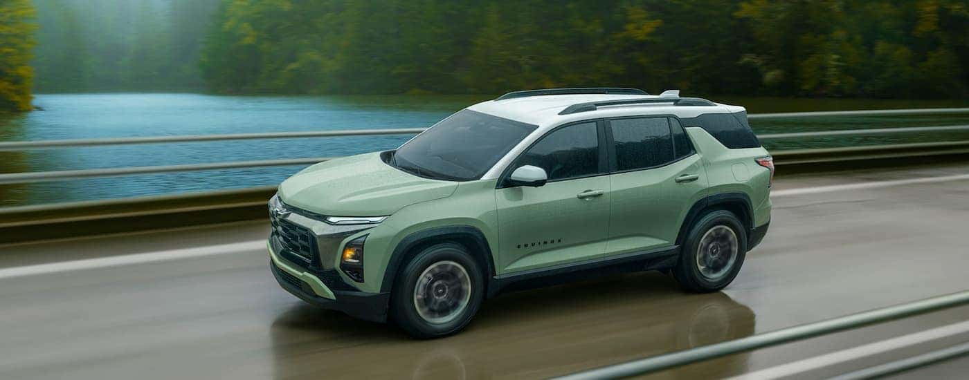 Green 2026 Chevy Equinox driving down a bridge.