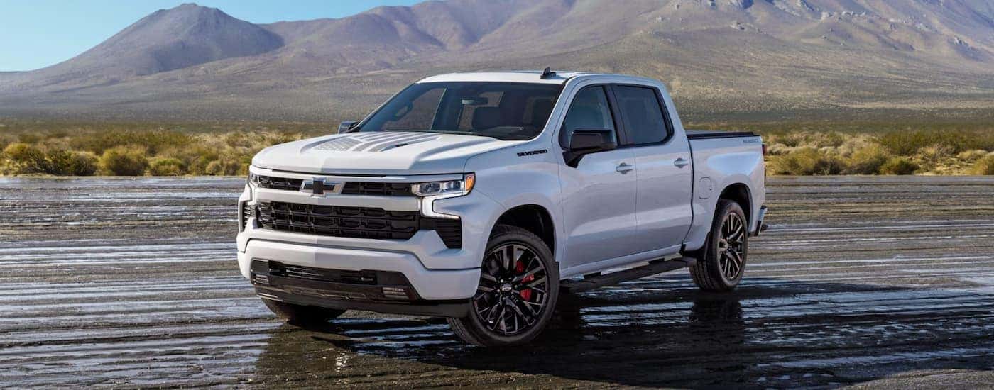 White 2026 Chevy Silverado 1500 driving down a muddy road.