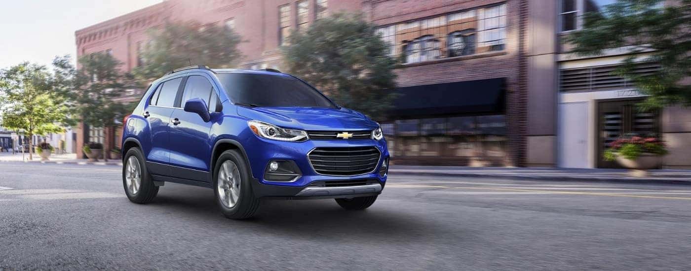 A blue 2017 Chevy Trax driving down a street.