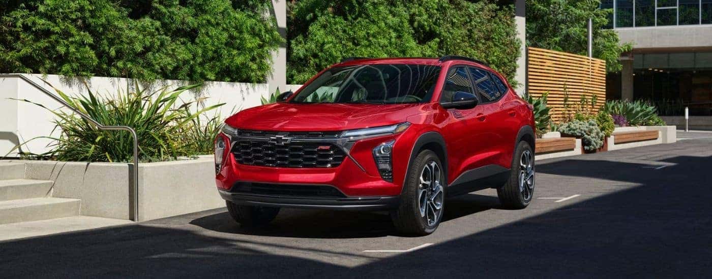 A red 2026 Chevy Trax 2RS parked by bushes.