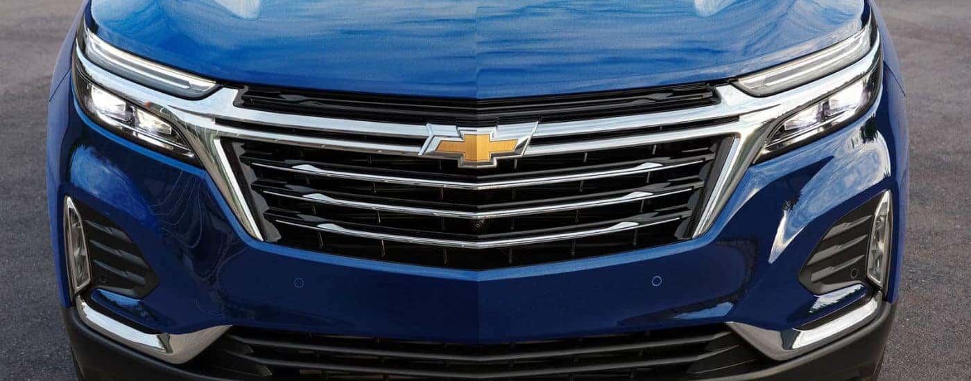 Front grille of a blue 2023 Chevy Equinox.